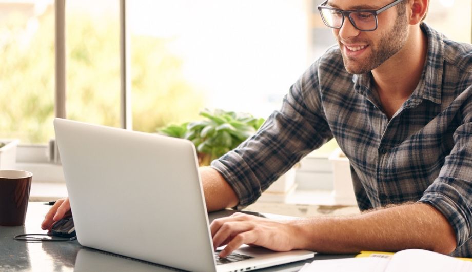 Happy man works on his laptop