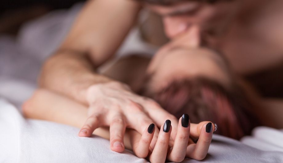 Young beautiful amorous couple making love in bed