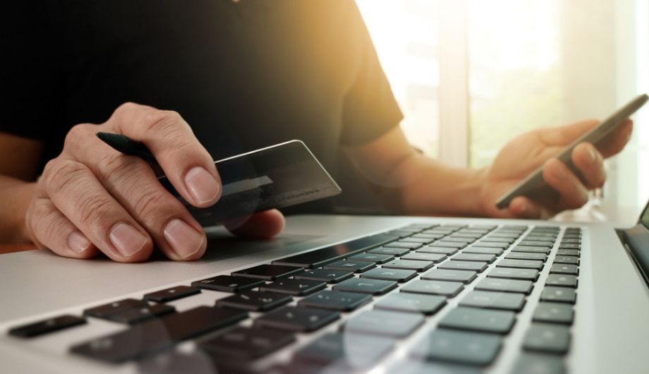 hands using laptop and holding credit card
